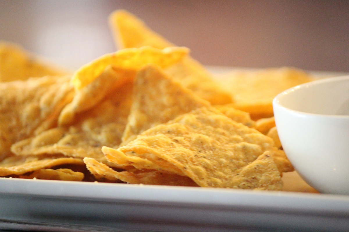close up of crispy corn chips on a white plate